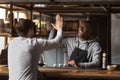 Smiling African American barista giving high five with customer Royalty Free Stock Photo