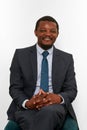 Smiling african american black man in business suit sitting on chair isolated on white background Royalty Free Stock Photo