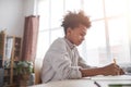 Smiling African-American Boy doing Homework by Window