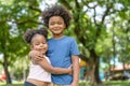 Smiling African American boy and little girl hugging together in park.Happy lovely kid young sister embrace her brother.Family and Royalty Free Stock Photo