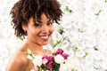 African american bride looking at camera while holding flowers Royalty Free Stock Photo