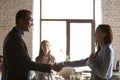 African American employer handshake congratulating excited female worker