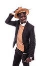 Smiling african american businessman using tablet wearing in suit and hat . Young man in suit working with portable computer, isol Royalty Free Stock Photo