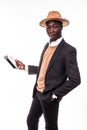 Smiling african american businessman using tablet wearing in suit and hat . Young man in suit working with portable computer, isol Royalty Free Stock Photo