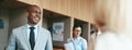 Smiling African American businessman walking with colleagues in an office Royalty Free Stock Photo