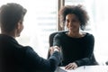 Smiling biracial businesswoman handshake close deal with male colleague Royalty Free Stock Photo