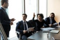 Smiling african american businesswoman raising hand asking mentor in boardroom. Royalty Free Stock Photo