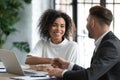 Smiling African American businesswoman shaking client hand at meeting