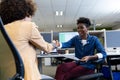Smiling african american businesswoman shaking hands with hispanic female colleague in cubicle Royalty Free Stock Photo