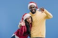 smiling african american couple in christmas hats waving by hands