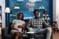 Smiling african american couple feeling happy watching TV Royalty Free Stock Photo