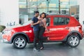 Smiling African American couple hugging and smiling at camera at new car showroom Royalty Free Stock Photo