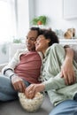 Smiling african american couple hugging near