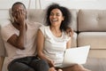Smiling african American couple laugh watching funny video on laptop Royalty Free Stock Photo
