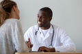 Smiling African American doctor talking to patient at visit