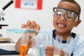 Smiling african american elementary schoolboy performing chemistry practical in laboratory Royalty Free Stock Photo