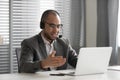 Smiling African American employee in headset using laptop, talking online Royalty Free Stock Photo