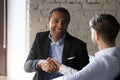 Smiling African American employee shaking hand of client at meeting Royalty Free Stock Photo