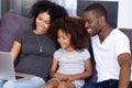 Smiling African American family using laptop together in living room Royalty Free Stock Photo