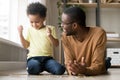 Smiling African American father and toddler son playing puzzle Royalty Free Stock Photo