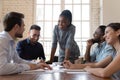 Smiling african american female leader listening to colleagues project ideas. Royalty Free Stock Photo