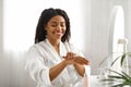 Smiling African American Female Using Moisturising Cream For Hands At Home Royalty Free Stock Photo