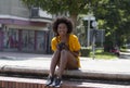 Girl holds a mechanical camera in hands and sits on the street.