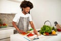 Smiling African American Guy Reading Paper Culinary Book In Kitchen Royalty Free Stock Photo