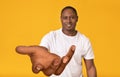 Smiling black guy stretching out his big hand, holding something, offering help, begging or reaching for something Royalty Free Stock Photo