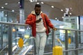 Smiling African American guy using smartphone, checking incoming messages after arrival to airport Royalty Free Stock Photo