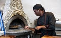 Positive man chef preparing pizza in pizzeria Royalty Free Stock Photo