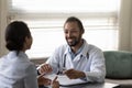 Smiling African American man doctor consulting Indian woman patient Royalty Free Stock Photo