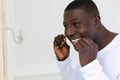 Smiling african american man flossing teeth in bathroom Royalty Free Stock Photo