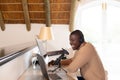 Smiling african american man in headphones making podcast at home using computer and microphone Royalty Free Stock Photo