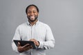 Smiling African-American man holding digital tablet isolated on grey Royalty Free Stock Photo