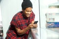 Smiling african american man looking at mobile phone Royalty Free Stock Photo