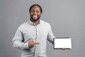 Smiling African-American man point finger on empty screen of tablet Royalty Free Stock Photo