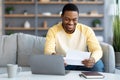 Smiling african american man reading letter at home Royalty Free Stock Photo