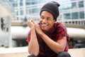 Smiling african american man sitting in city and looking away Royalty Free Stock Photo