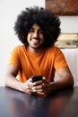 Smiling african american man sitting at home with mobile phone Royalty Free Stock Photo