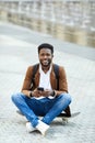 Smiling African-American Man Texting in City Square Royalty Free Stock Photo