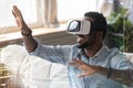 Smiling African American man in VR glasses enjoying augmented reality