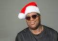 Smiling African American man wearing a Santa Claus hat against a solid background Royalty Free Stock Photo