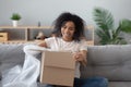 Smiling black girl unpack parcel at home shopping online Royalty Free Stock Photo