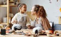 Smiling african american mother and child girl paint  Halloween pumpkins while sitting in cozy kitchen Royalty Free Stock Photo