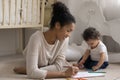 Smiling African American mother and toddler girl drawing colorful pencils Royalty Free Stock Photo