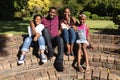 Smiling african american parents with daughter and son sitting embracing outdoors Royalty Free Stock Photo