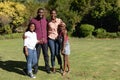 Smiling african american parents with daughter and son standing embracing outdoors Royalty Free Stock Photo