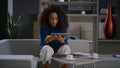 Smiling african american professional woman scrolling phone tablet in office.