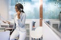 Smiling African-american secretary talking on the landline phone and holding paper in the office. Royalty Free Stock Photo